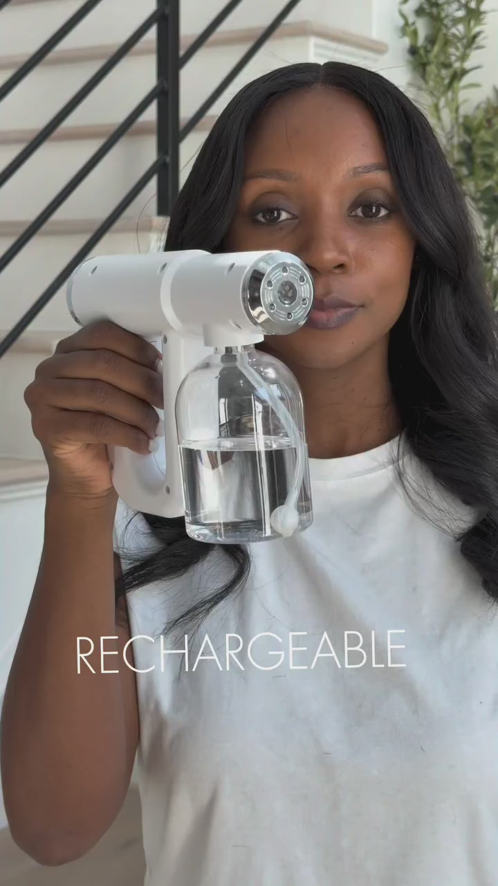 The AeroClean sanitizer gun spraying a fine blue-lit mist over a household surface.